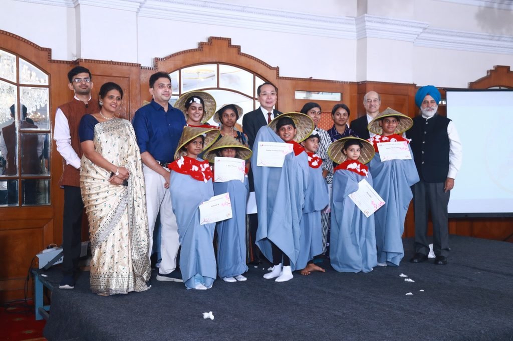 Ananya Mukesh standing to the left of Guest of Honour Mr Nakane Tsutomu, Consulate General of Japan in Bengaluru in a group photograph with other chief guests and skit participants on the occasion of 25th anniversary of Sakuraa Nihongo Resource Centre at Bengaluru, India